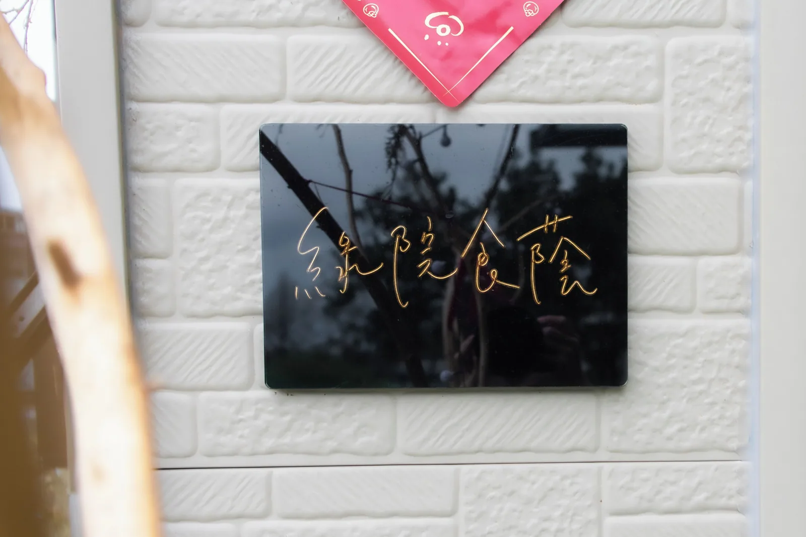 招牌與門口:黑底金字,門前鋪的是綠色人工草皮
